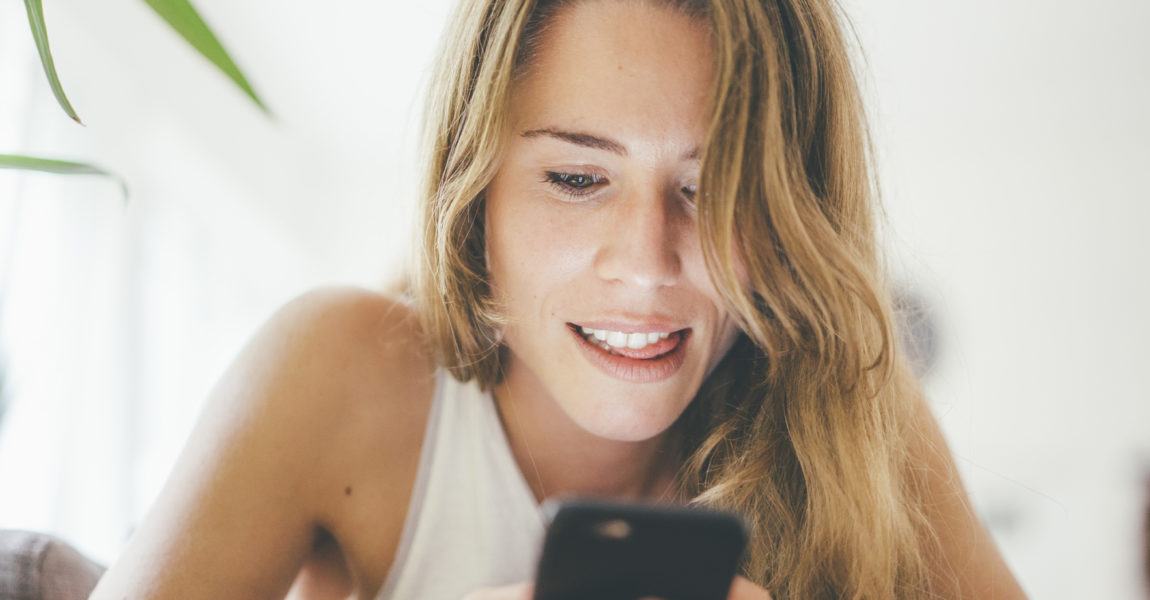 Young woman looking at cell phone Essen, NRW, Deutschland, w24, zuhause 