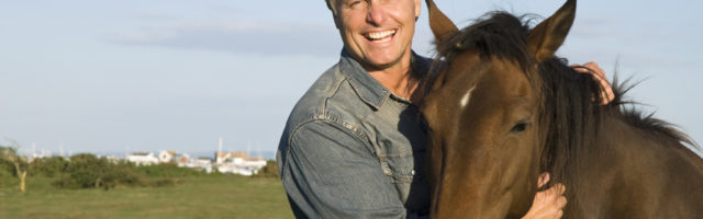 happy man petting his horse 