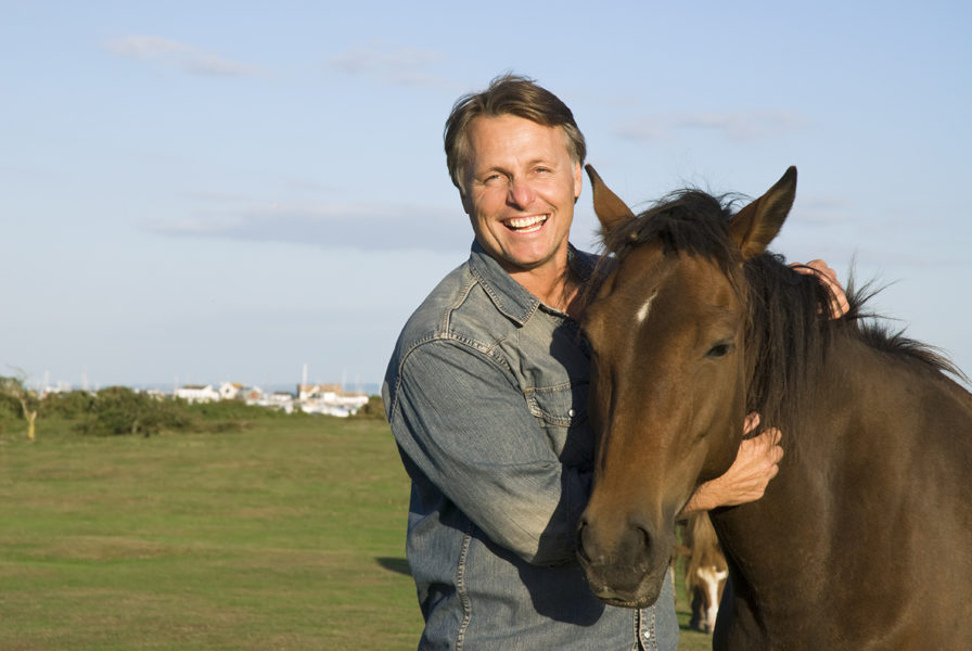 happy man petting his horse 