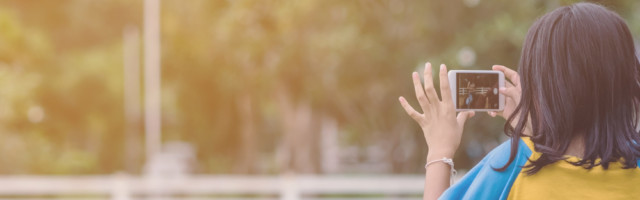 Girl in yellow and blue shirt use smartphone to take photos at the horse riding field in the evening. Girl in yellow and blue shirt use smartphone to take photos at the horse riding field in the evening. 