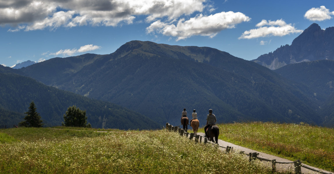 three people ride over the mountains 
