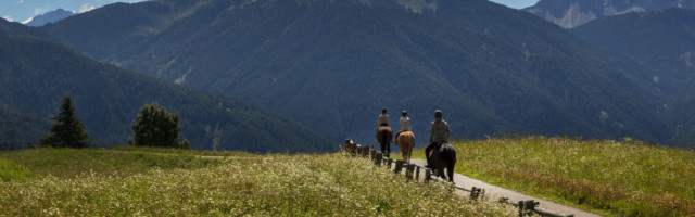three people ride over the mountains 