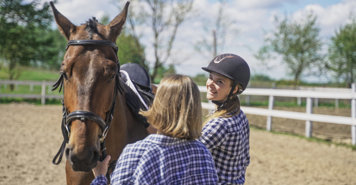 Two,Young,Women,In,Plaid,Shirts,Prepare,A,Horse.,High-quality two young women in plaid shirts prepare a horse. High-quality photo 