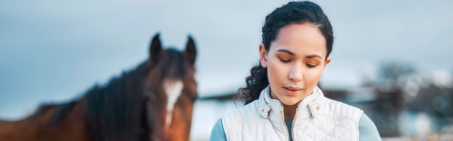 I cant wait to post this. an attractive woman using her cellphone while posing with a horse in an enclosed pasture on a farm. an attractive woman using her cellphone while posing with a horse in an enclosed pasture on a farm. 